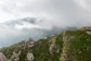 A group of hikers walking on the ridge of a grassy mountain.